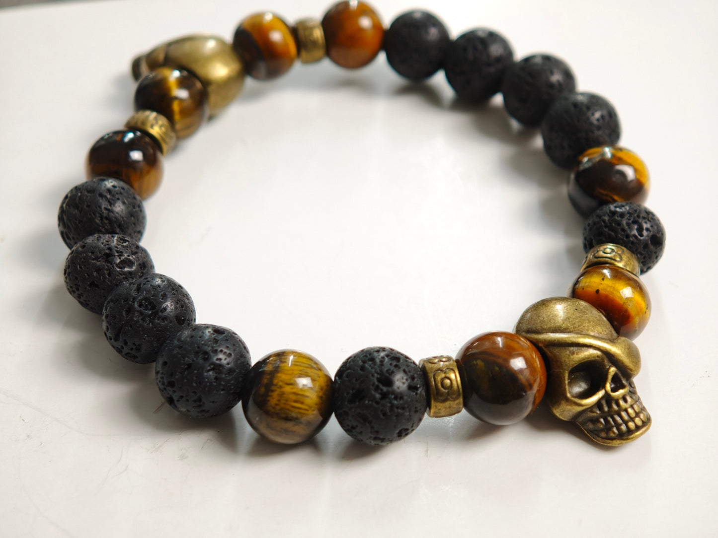 Edelstein-Armband „Earth & Fire“ – Tigerauge & Lavastein mit Bronze-Skulls